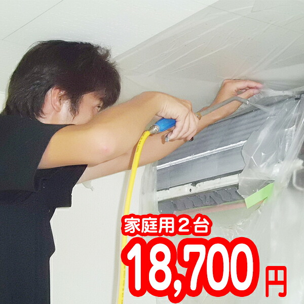 エアコンを養生してノズルで内部を洗浄している作業の様子
