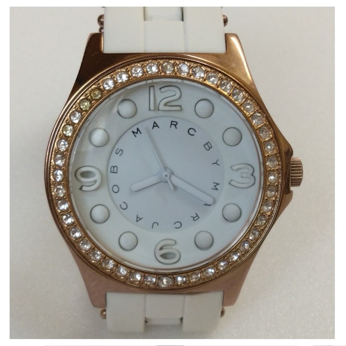 【中古】マークジェイコブスの女性用の金色シャンパンゴールド色メタル素材にベゼルに綺麗なラインストーンが埋め込まれている白いラバー素材のベルトを使用している時計 2ヵ月保証付き 〇A19-29 X-39