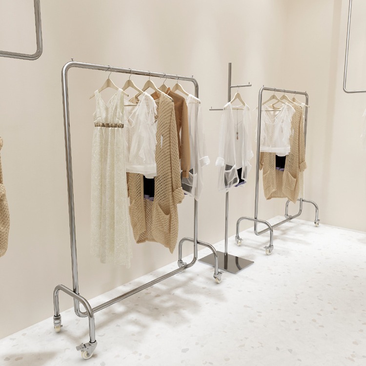 服飾店用衣類掛け軸 ステンレス製ベルト付きホイール 銀色中島型フロアディスプレイラック 女性服店棚 装示ラック