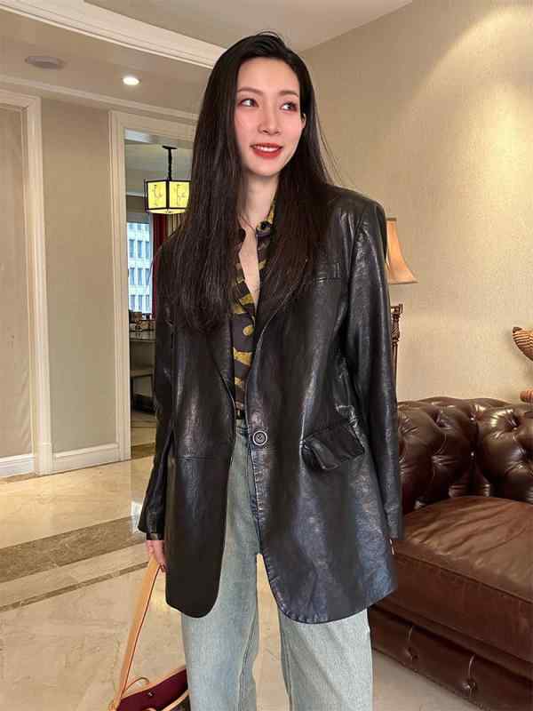 オイル ワックスの 皮の 服の 女性は ゆったり して いて、 痩せて います。