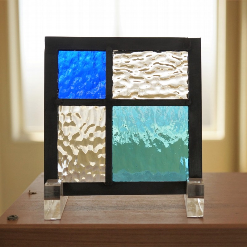 <br>ステンドグラス パネル 住宅用 4つのガラス 格子 ブルー×水色×クリア4種のガラス 12cm×12cm　<br>【ステンド 室内窓 壁埋め込み 小窓 スクエア 青 パステルカラー 明かり採り 新築 改築 新生活 リフォーム インテリア 建材パーツ 空間アクセント 室内装飾 壁装飾】