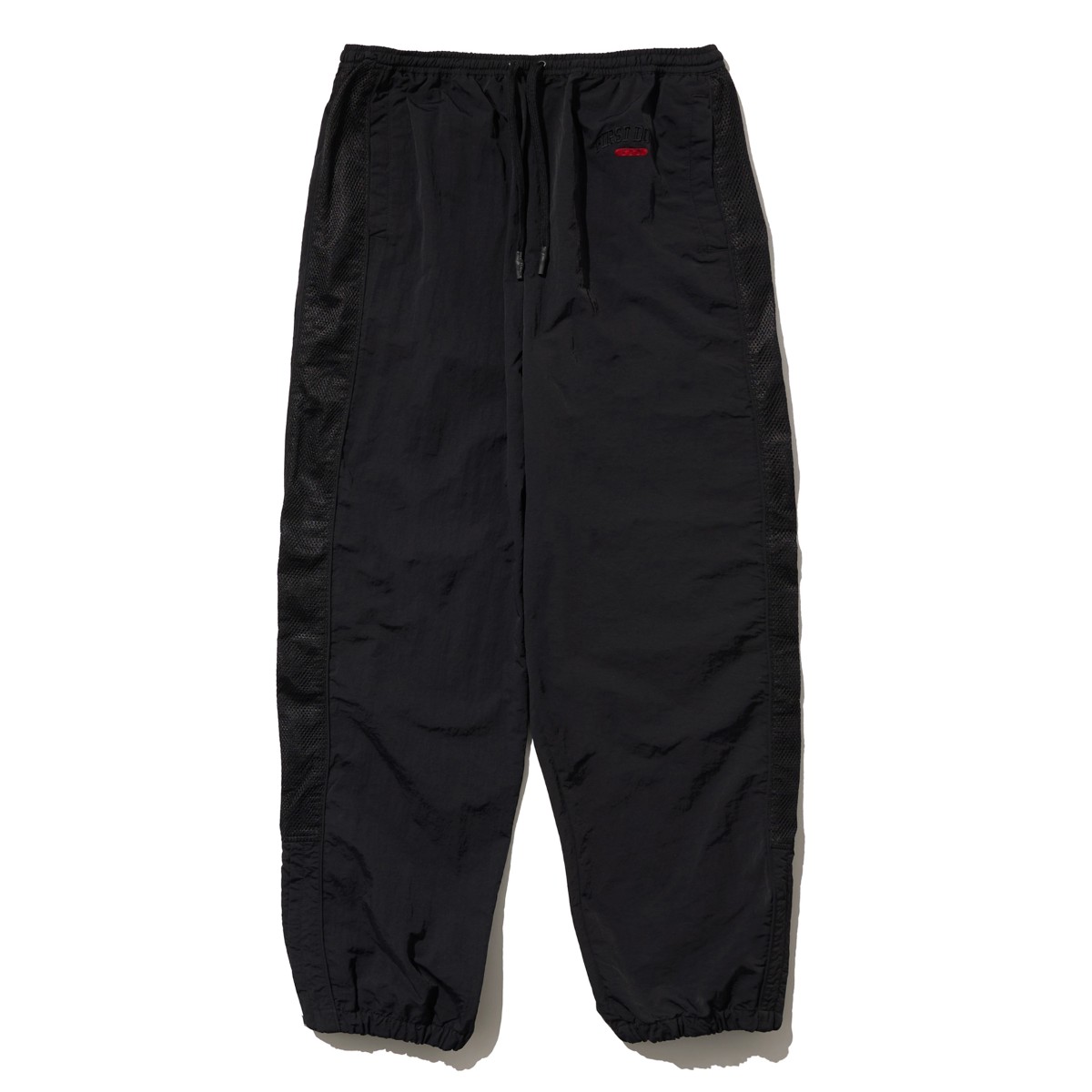 【20%OFF】FIRST DOWN TASLAN NYLON TRACK PANTS(BLACK)(ファーストダウン タスランナイロン トラックパンツ)【メンズ レディース】【ナイロンパンツ 裾ジップ ワンポイント シンプル】【25SS】｜Kinetics