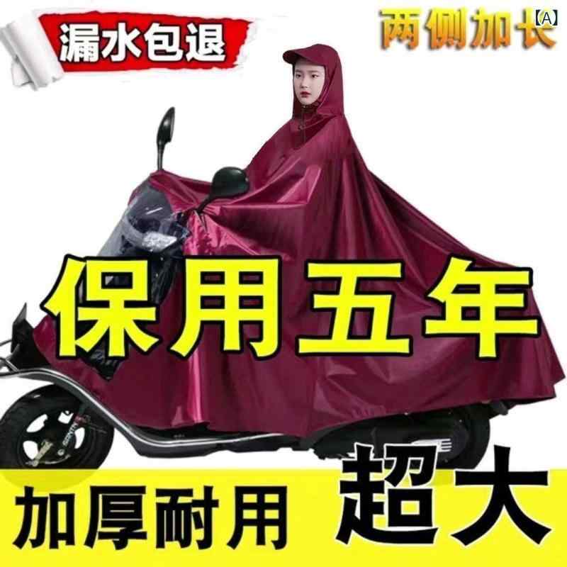 レインコート 電気 自動車の レインコートを 大きく して、 オートバイの 二 人の シングル 男性 女性が 豪雨 防止 全身に 足を 隠します。