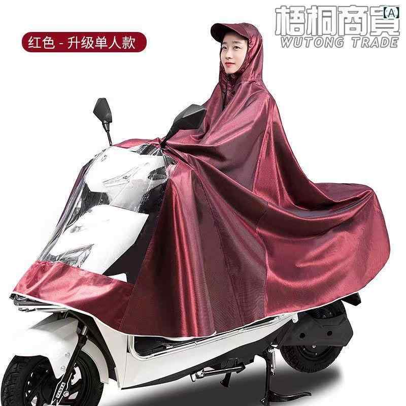 レインコート 電気 自動車の レインコートを 大きく して、 オートバイの 二 人の シングル 男性 女性が 豪雨 防止 全身に 足を 隠します。